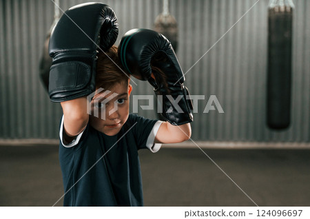Portrait of boy that is practicing boxing in the gym with glowes on hands 124096697