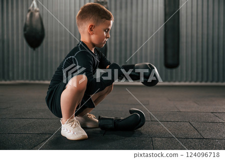 Wearing the glowes. Boy is practicing boxing in the gym 124096718