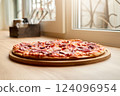 A delicious pepperoni pizza rests on a wooden board, positioned near a bright window. Sunlight glimmers on the cheese, creating an inviting atmosphere in the eatery 124096954