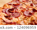 Freshly baked pizza is topped with savory pepperoni, sausage, and sliced onions, showcasing a crispy crust and melted cheese. Perfect for a casual meal at home 124096959