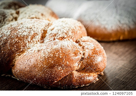 Braided buns bread decorated with sugar above on a wooden table background Braided buns bread decorated with sugar above on a wooden table background 124097105