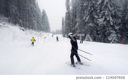 People skiing on the snowy slope of Bukovel ski resort in the Ukrainian Carpathian mountains. 124097608