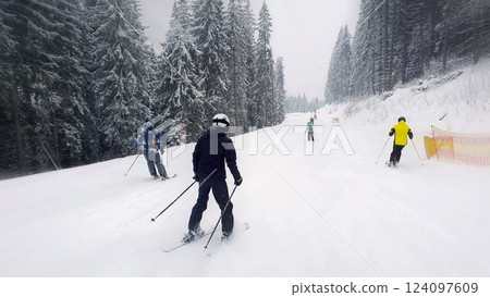 People skiing on the snowy slope of Bukovel ski resort in the Ukrainian Carpathian mountains. 124097609