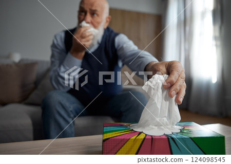 Selective focus on senior man hand taking napkin from box holder Selective focus on senior man hand taking napkin from box holder 124098545