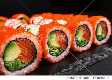 Delicious Fresh Sushi Rolls Set Presenting Exquisitely on a Black Background Delicious Fresh Sushi Rolls Set Presenting Exquisitely on a Black Background 124098606