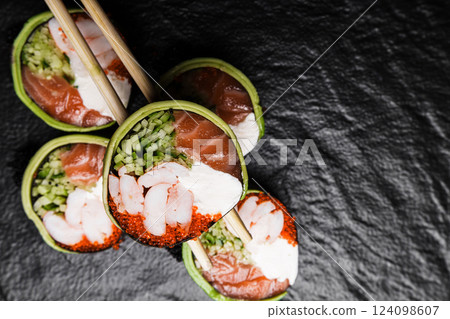 Fresh Sushi avocado shrimp Rolls Presenting Exquisitely on a Black Background Fresh Sushi avocado shrimp Rolls Presenting Exquisitely on a Black Background 124098607