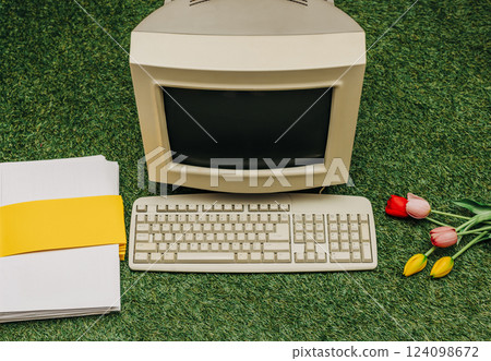 Vintage PC, tulips and documents on green grass, top view. Monitor and keyboard as in 90s Vintage PC, tulips and documents on green grass, top view. Monitor and keyboard as in 90s 124098672