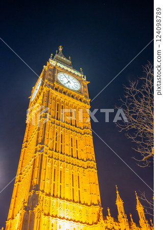 Big Ben stands tall and illuminated against the night sky in London, England. The historical clock tower showcases intricate architecture and glowing lights, creating a stunning night view. Big Ben stands tall and illuminated against the night sky in London, England. The historical clock tower showcases intricate architecture and glowing lights, creating a stunning night view. 124098789