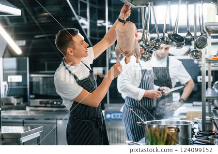 In uniform. Kitchen workers is together preparing the food 124099152