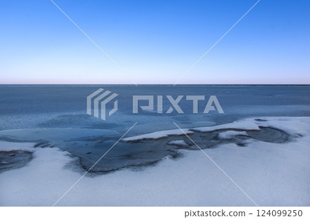 snow-covered lake shore with melting ice snow-covered lake shore with melting ice 124099250