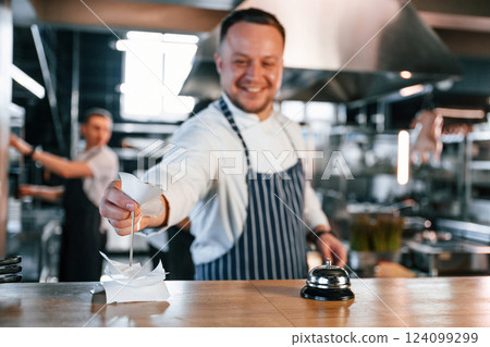 Order is complete. Kitchen workers is together preparing the food 124099299