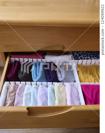 The linen from the dresser drawer is beautifully laid out in its places. The concept of order, storage and organization of space. 124099922