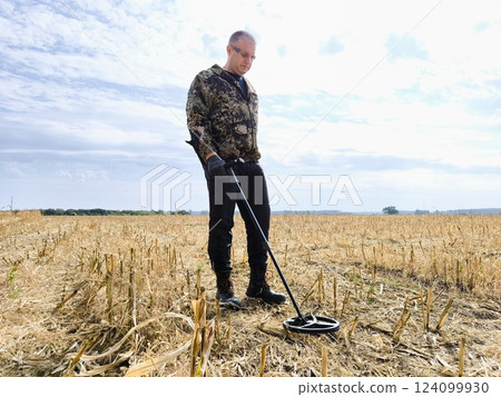 Archeology. man with a metal detector searches for treasures. Man with a metal detector. metal detector at work in the forest or field 124099930