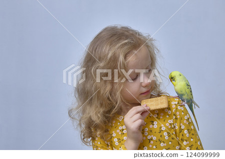 A girl feeds a parrot with junk food. 124099999