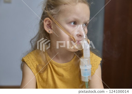 The sick girl is breathing and being treated with a nebulizer. The sick girl is breathing and being treated with a nebulizer. 124100014