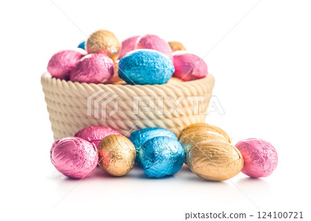 Chocolate easter eggs wrapped in multi colored foil in bowl isolated on white background. 124100721