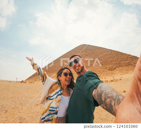 Happy tourists couple taking selfie in front of the red pyramid, dahshur, egypt 124101060
