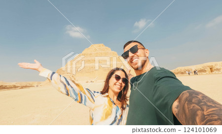 Tourists taking selfie with saqqara step pyramid in background, egypt Tourists taking selfie with saqqara step pyramid in background, egypt 124101069