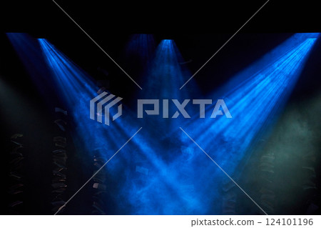 Spotlights illuminate empty stage blue background. 124101196