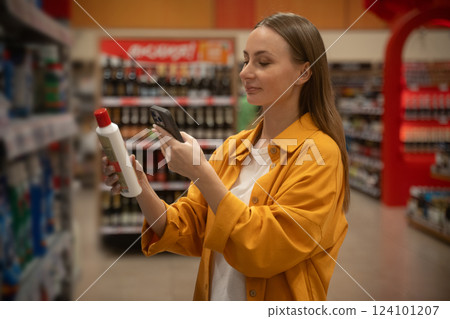 Exploring household chemicals while scanning products in a retail store during daytime shopping Exploring household chemicals while scanning products in a retail store during daytime shopping 124101207