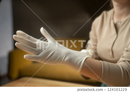 Putting on medical gloves in a clinical setting to ensure safety and hygiene before patient care 124101229