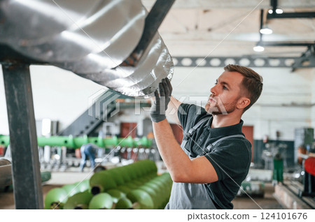 Sharp edges of equipment. Man in uniform is in workstation developing details of agriculture technique 124101676