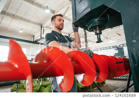 Professional engineer operating machine. Man in uniform is in workstation developing details of agriculture technique 124101689