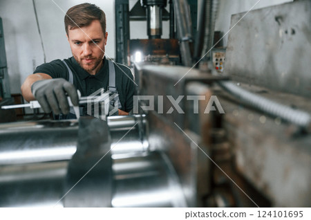 Using measure tool. Man in uniform is in workstation developing details of agriculture technique 124101695