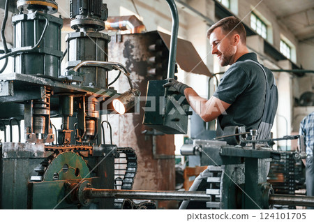 Metal processing device. Man in uniform is in workstation developing details of agriculture technique 124101705