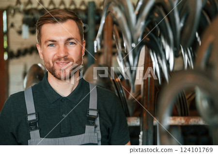 Portrait of man in uniform that is in workstation developing details of agriculture technique Portrait of man in uniform that is in workstation developing details of agriculture technique 124101769