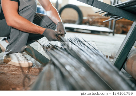 Taking metal pieces. Man in uniform is in workstation developing details of agriculture technique Taking metal pieces. Man in uniform is in workstation developing details of agriculture technique 124101799