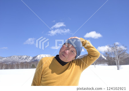 An old man stretching under the blue sky on a sunny day in a snowy country An old man stretching under the blue sky on a sunny day in a snowy country 124102921