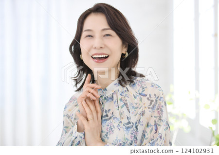 A smiling middle-aged woman wearing a floral blouse 124102931