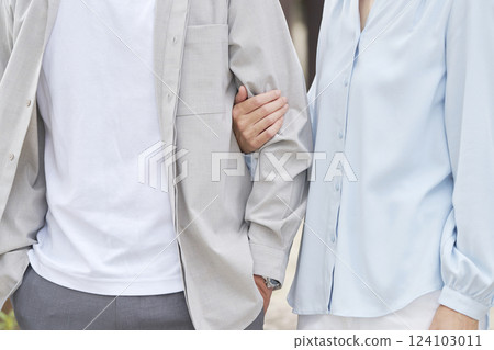 Middle-aged couple with arms folded, no faces 124103011