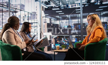 General director reviewing data analytics with her team for successful development plan, working hard to expand the business globally. CEO showing great leadership skills, briefing meeting. Camera B. 124103111