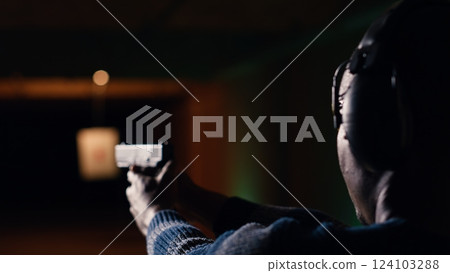 Person wearing safety glasses loading pistol ammo magazine during firearm practice session at shooting range. Close up of BIPOC man reloading gun, learning self defense, pointing weapon Person wearing safety glasses loading pistol ammo magazine during firearm practice session at shooting range. Close up of BIPOC man reloading gun, learning self defense, pointing weapon 124103288