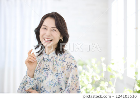 一位身穿花襯衫、微笑的中年婦女 一位身穿花襯衫、微笑的中年婦女 124103530