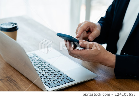 一個操作電腦和智能手機的人 124103655