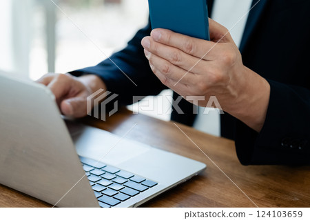一個操作電腦和智能手機的人 124103659