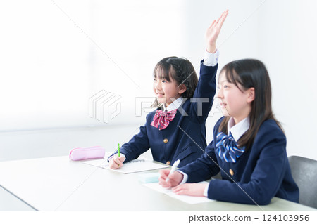 A girl raising her hand during class at school 124103956