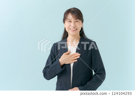 A middle-aged woman smiling with her hand on her chest A middle-aged woman smiling with her hand on her chest 124104293