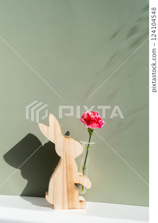 Minimalistic creative Easter concept. Two Easter bunnies under symbolic roof on green background. Celebration Easter holiday at home with family. Poster or greeting card 124104548