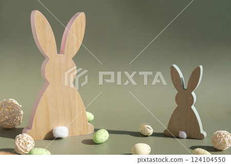 Minimalistic creative Easter concept. Two Easter bunnies under symbolic roof on green background. Celebration Easter holiday at home with family. Poster or greeting card 124104550