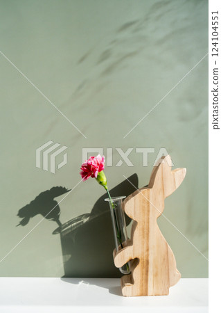 Minimalistic creative Easter concept. Two Easter bunnies under symbolic roof on green background. Celebration Easter holiday at home with family. Poster or greeting card 124104551