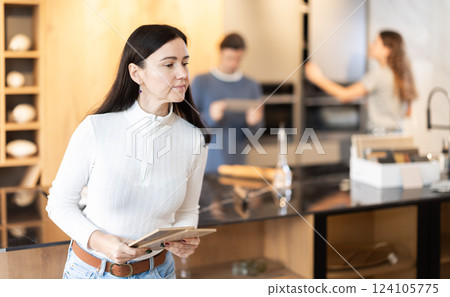 Adult woman choosing wood for floor in furniture salon 124105775