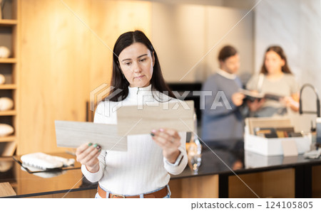 Adult woman choosing wood for floor in furniture salon 124105805