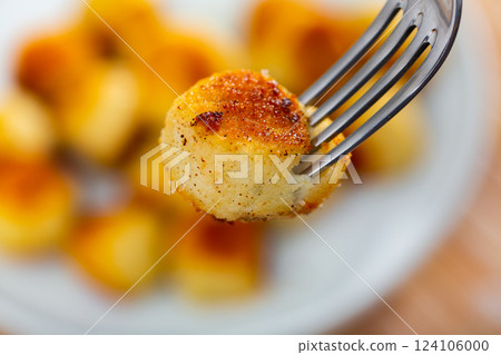 Cheese croquette with crunchy coating and creamy filling on fork Cheese croquette with crunchy coating and creamy filling on fork 124106000