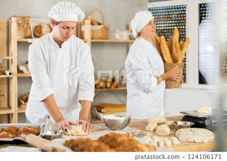 Man works in bakery as baker, kneads dough, works with flour. Man works in bakery as baker, kneads dough, works with flour. 124106171