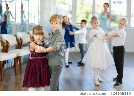 Smiling little boys and girls dancing pair dance in ballet studio Smiling little boys and girls dancing pair dance in ballet studio 124106310