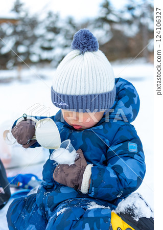 Boy playing in the snow 124106327